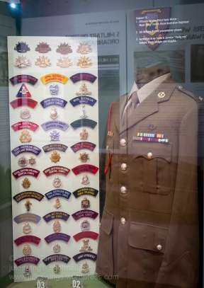 Cabinet display featuring the Officer's Service Dress Winter tunic worn by Major Doug French of the Royal Australian Regiment, 5th Military District presentation plaque and Australian Army insignia. Photo: Julian Tennant