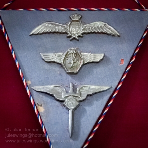 3 badges made by a Prisoner of War from silver foil used in cigarette packets. These were made in 1944 by Sgt K.T. Sneider, a Czech POW. The cord represents the Czechoslovkian national colours. Top to bottom - RAF Pilot Wings, POW Parachute club and a Czech Air Force Badge. Photo: Julian Tennant