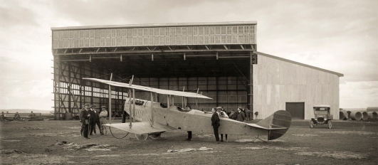 The NSW State Aviation School July 21, 1916, just before officially opening. Timber for the western annexe of the hangar still lies stacked on the ground, as the first Curtis 'Jenny' trainer aircraft is checked out by Chief Instructor Billy Stutt (nearest camera) and the workers who had assembled and rigged the airframe. Hurried patches in the aerodrome surface indicate the pace of preparations towards the official opening of the School on August 28, 1916. Picture: www.3squadron.org.au. Charter Family Collection